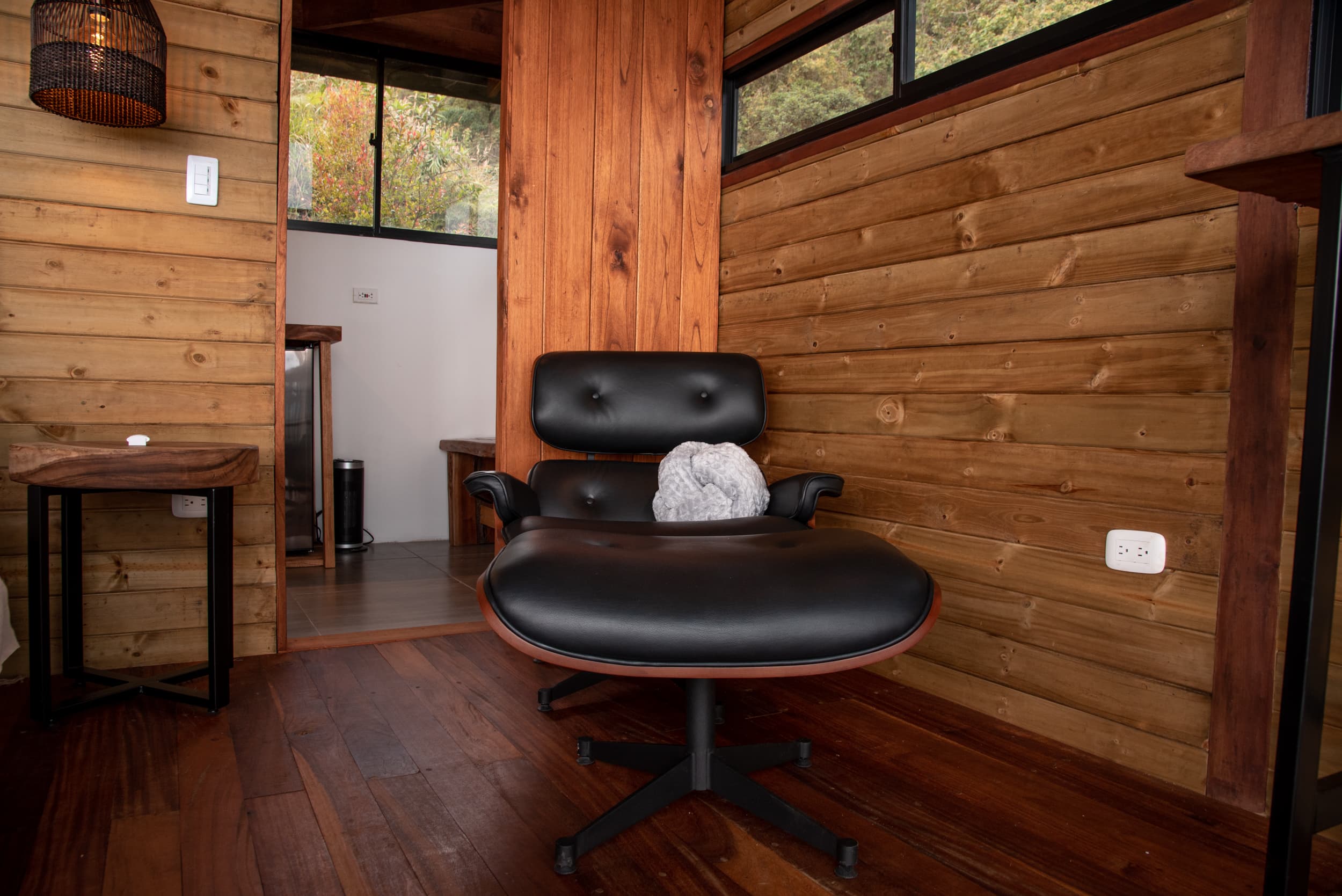 Eames-style lounge chair, warm wood walls